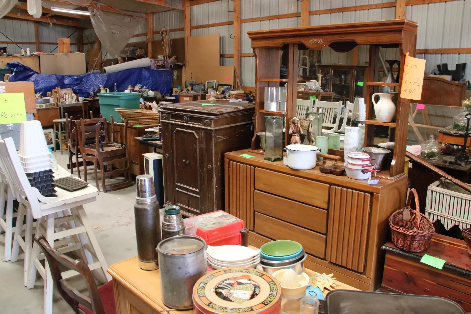 Antique furniture and vintage household goods arranged inside a Nebraska sale barn