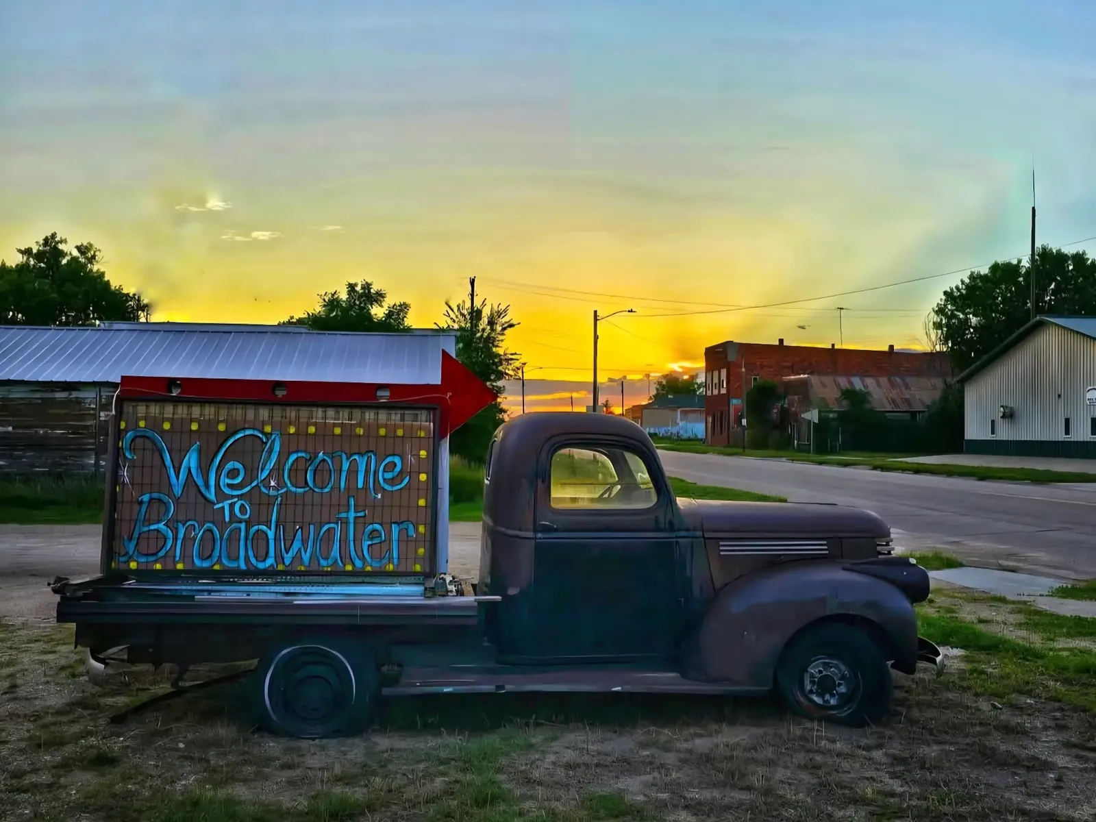 Vintage truck with a Welcome to Broadwater sign at sunset